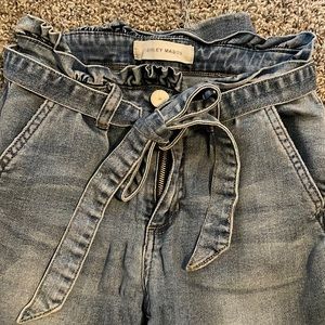 Ashley Mason High Rush Skinny Jeans, frill top with denim belt.